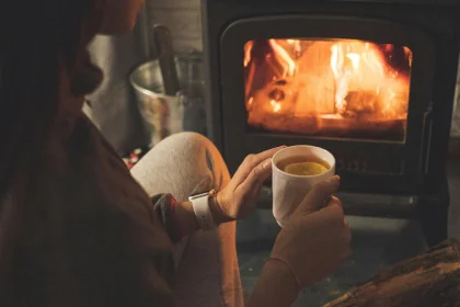 woman in front of fire holding hot chocolate providing heating