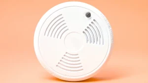 Smoke alarm on an orange background. WA Smoke Alarm Laws